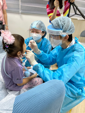 牙醫為一名參與研究的兒童進行口腔檢查，並收集她的牙菌膜樣本。